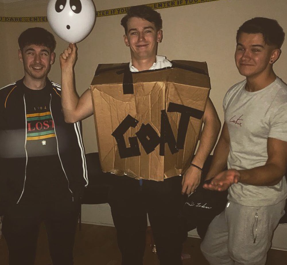 A young Moe in a cardboard GOAT costume, flanked by Sam and Cavner at a party
