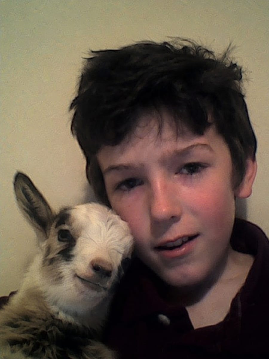 A young Moe Manson cheek-to-cheek with his first goat