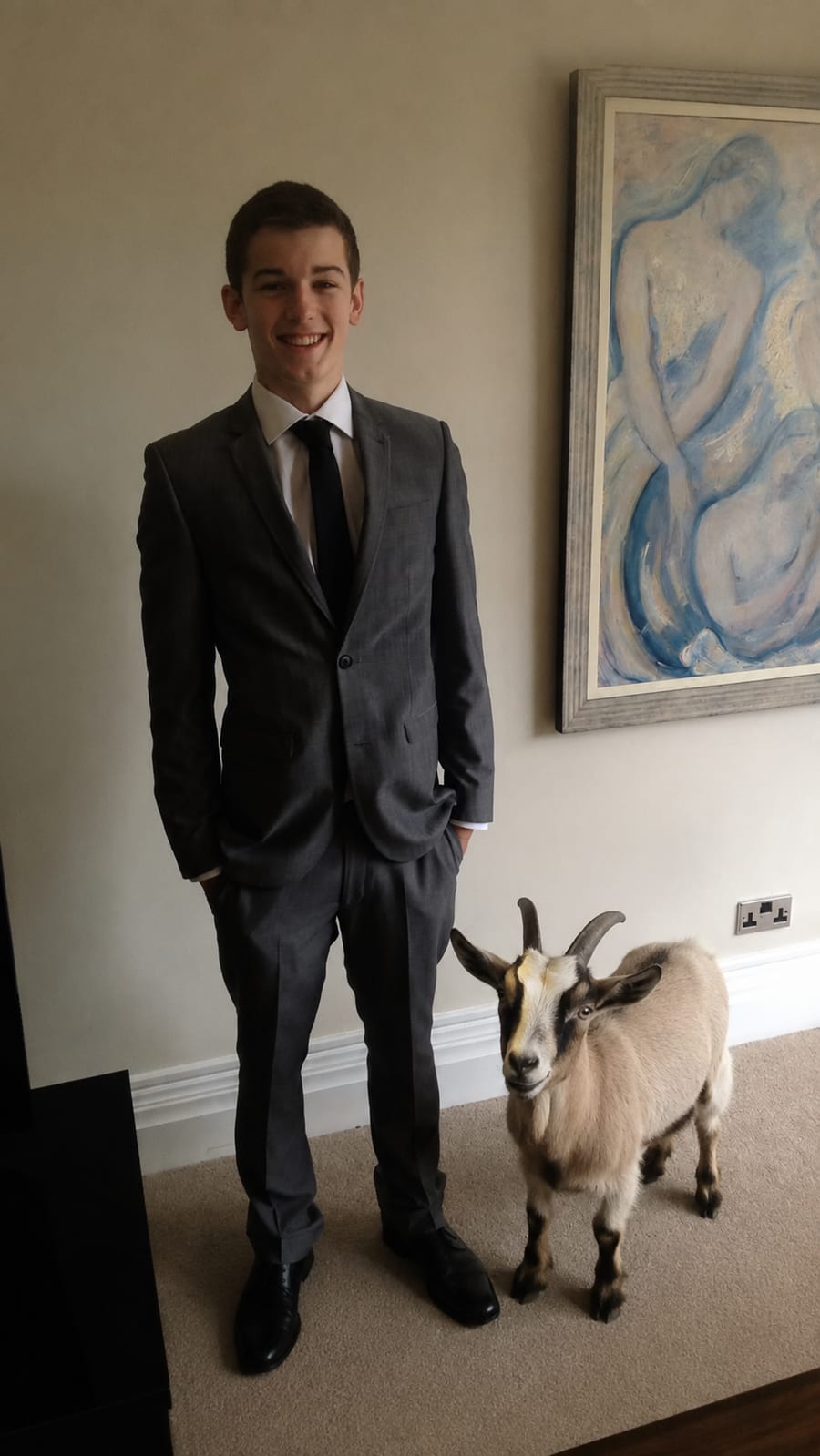 A teenage Moe Manson in a tailored suit beside a goat