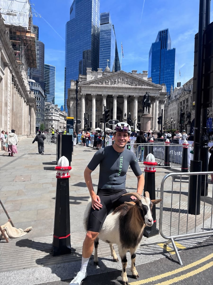 Oli Shoosmith in cycling kit with a goat in the City of London