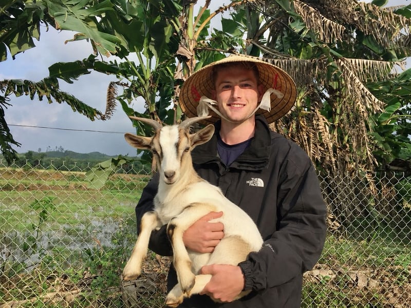 Sam Eastaugh in a conical hat holding a goat